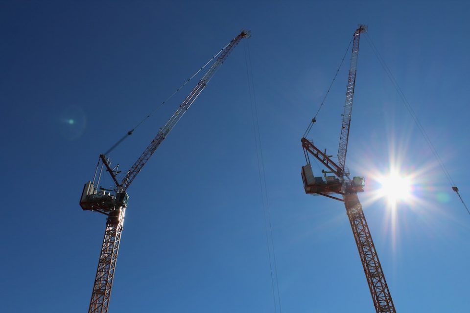Two cranes reach skyward
